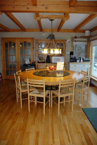 a kitchen with a large wooden table and chairs at Gîte Au Perchoir in Baie-Saint-Paul