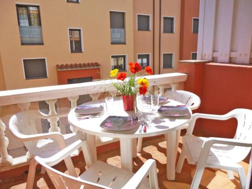 エンプリアブラバにあるBasic Comfort Apartment Gran Reserva 0070の白いテーブルと椅子(花の咲くバルコニー付)