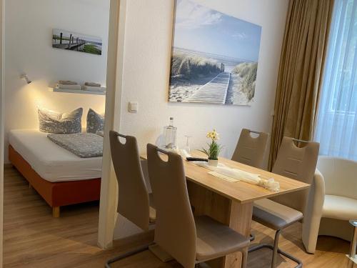 ein Esszimmer mit einem Tisch und einem Bett in der Unterkunft Wilsmann Apartmentvermietung in Hövelhof