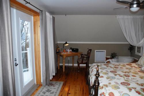 a bedroom with a bed and a bathroom with a tub at Gîte Au Perchoir in Baie-Saint-Paul