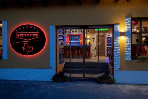 a restaurant entrance with a red sign on the door at Radics Panzió Étterem és Pihenő Központ in Letenye