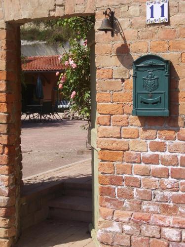 a green mailbox on the side of a brick wall at Guest House I Vicini di Cesare in Castelnuovo