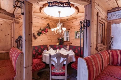 a dining room with a table and a chandelier at Hotel Pramstraller in Mayrhofen