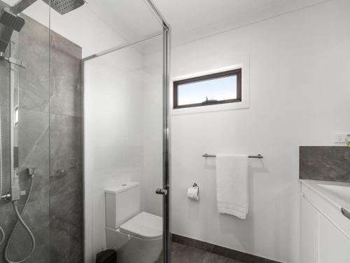 a bathroom with a shower and a toilet and a sink at Rosebud Beachside Gem in Rosebud