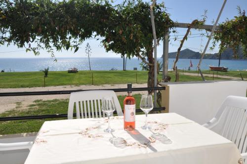 a table with a bottle of wine and two glasses at ELIAS & VASILI HOUSE in Agios Georgios Pagon