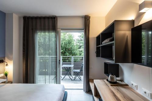 ein Hotelzimmer mit einem Bett und einer Glasschiebetür in der Unterkunft SEI Garda Apartments in Peschiera del Garda