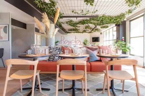 a restaurant with two tables and chairs and a couch at ibis Nice Aéroport Promenade des Anglais in Nice