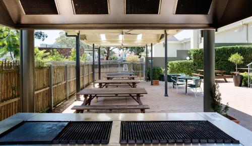 a group of picnic tables on a patio at Nightcap at Pritchards Hotel in Mount Pritchard