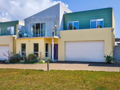 a house with two garage doors in front of it at Thalassa I Pet Friendly I 2 Mins Walk to Beach in Culburra Beach