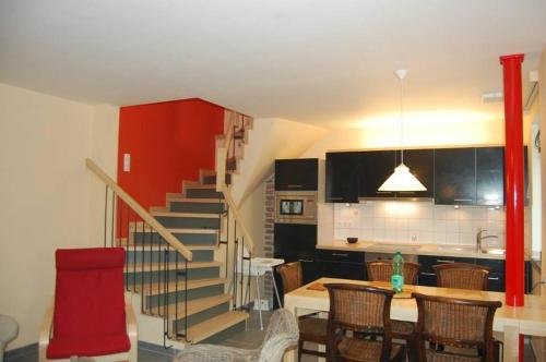 a kitchen and dining room with a staircase and a table at Le Clos des Haies, Silenrieux in Cerfontaine