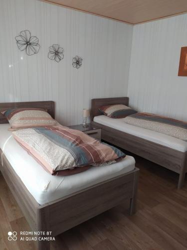 Habitación con 2 camas individuales y suelo de madera. en Ferienwohnung- Haus Anna, en Papenburg