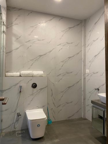 a white bathroom with a toilet and a sink at Theory9 Premium Service Apartments Khar in Mumbai