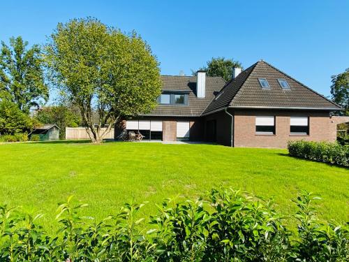 a house with a large yard with green grass at Ferienwohnung Jette in Westerstede