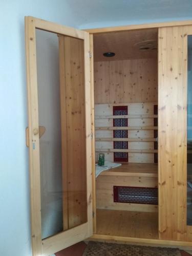 a sauna with a glass door in a room at Tettyei Házikó in Pécs