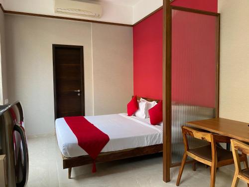 a bedroom with a bed with a red accent wall at Theory9 Premium Service Apartments Khar in Mumbai