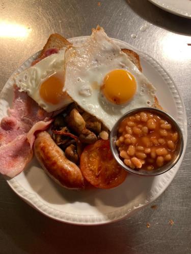 Un plato de desayuno con huevos y frijoles. en The Waie Inn, en Copplestone