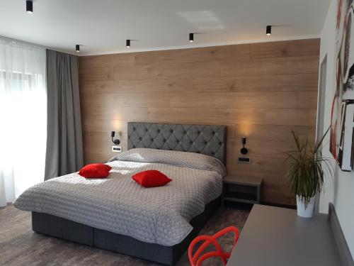 a bedroom with a bed with red pillows on it at Vila Trapez in Braşov