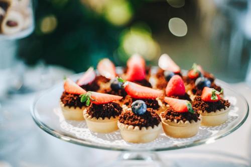 a plate of cupcakes with fruit on top on a table at Hotel Villa Fanny in Cagliari