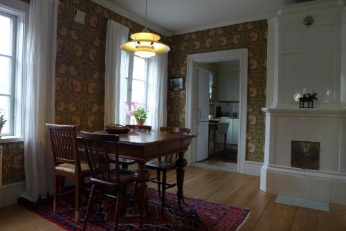 a dining room with a table and chairs and a fireplace at Prästgatanett Apartments in Östersund