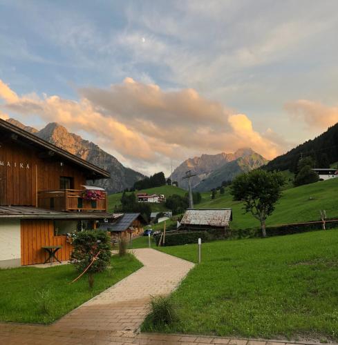a path leading to a house with mountains in the background at bi dr Gondamaika in Hirschegg