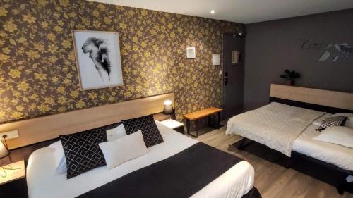 a hotel room with two beds and a picture on the wall at Celtic Hotel in Auray