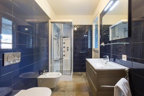 a bathroom with a toilet and a sink and a shower at Roggia Apartments by Quokka 360 - central flats with parking space in Lugano