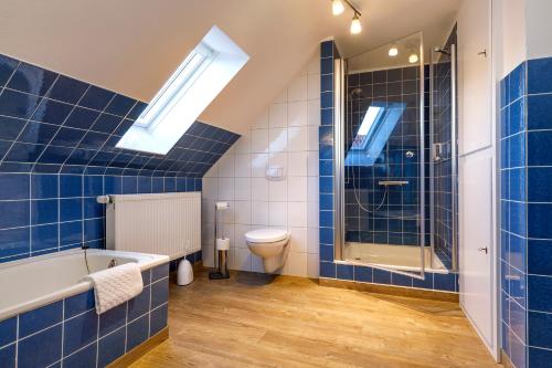 a bathroom with a tub and a toilet and a shower at Gästehaus Drostenhof in Rees