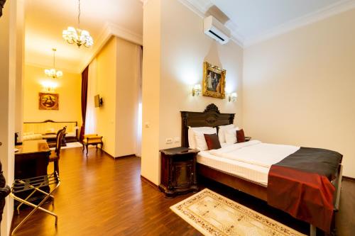 a hotel room with a bed and a dining room at Picasso Boutique Hotel in Arad