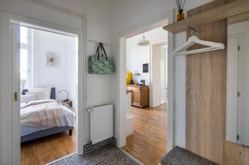 Schlafzimmer mit einem Bett und einer Tür, die in ein Zimmer führt in der Unterkunft Goger Apartman in Sopron