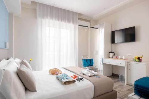 a bedroom with a white bed with a blue chair at B&Blue in Reggio di Calabria
