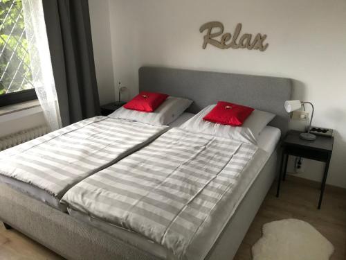 - un lit avec 2 oreillers rouges dans une chambre dans l'établissement Burgblick, à Nideggen