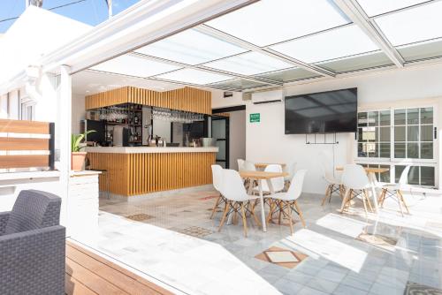 eine offene Küche und ein Esszimmer mit einem Tisch und Stühlen in der Unterkunft Hotel La Milagrosa in Alicante