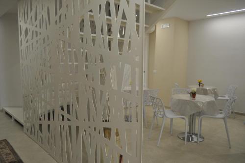 un mur dans une pièce avec une table et des chaises dans l'établissement In & Out Matera, à Matera