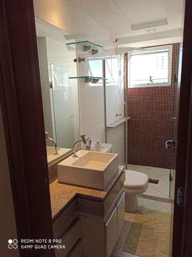 a bathroom with a sink and a toilet at Apartamento setor bueno in Goiânia