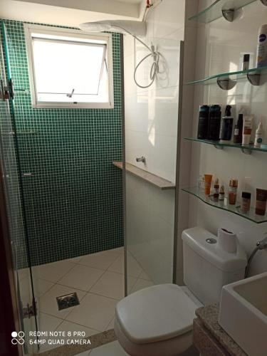 a bathroom with a toilet and a shower with a window at Apartamento setor bueno in Goiânia