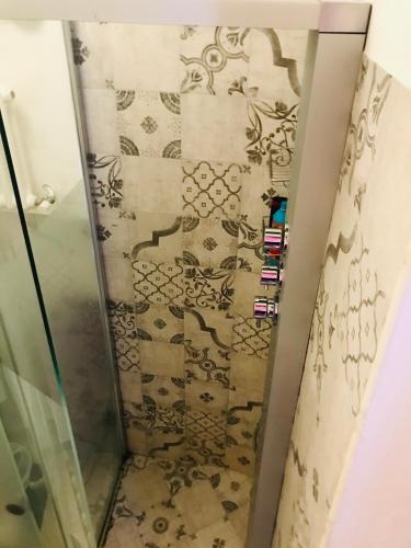 a shower with a glass door in a bathroom at Le Statuine Dimore Diffuse in Barletta