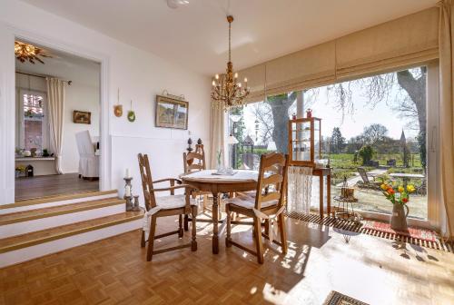 a dining room with a table and chairs and a large window at Gästehaus Drostenhof in Rees