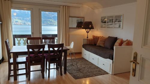 sala de estar con mesa, sofá, mesa y sillas en Appartement Harrer, en Zell am See