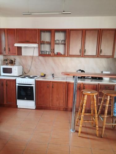 a kitchen with wooden cabinets and a counter with stools at Вила Мариам Villa Mariam in Batak