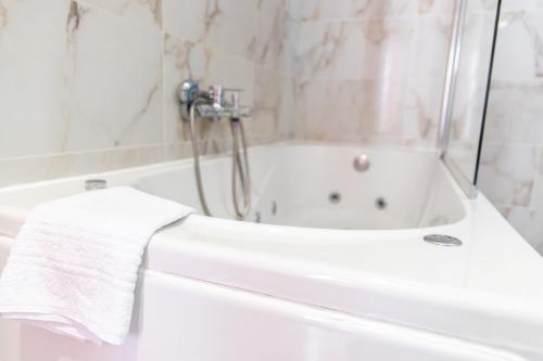 a bathroom with a bath tub with a towel on it at Hotel Muchacho in Macedo de Cavaleiros