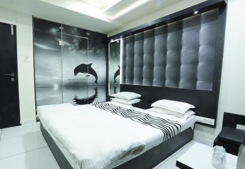 sypialnia z dużym łóżkiem z czarnym zagłówkiem w obiekcie Hotel Paramount Inn w mieście Radźkot