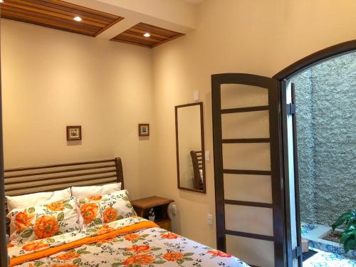 a bedroom with a bed with a ladder and a mirror at Cantinho Cunhense in Cunha
