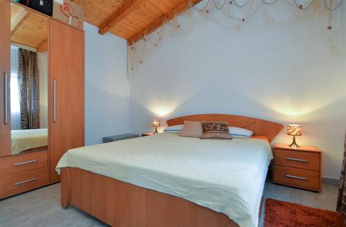 um quarto com uma cama grande e uma cómoda com 2 candeeiros em Apartments Jadranka 1279 em Pomer