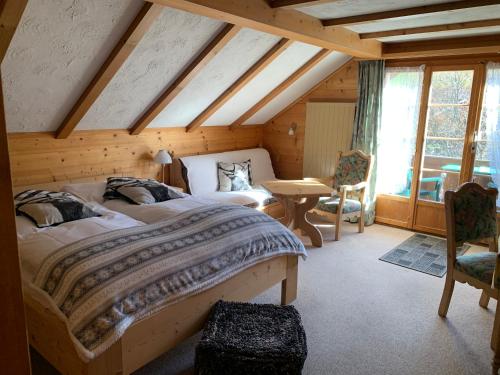 ein Schlafzimmer mit einem großen Bett im Dachgeschoss in der Unterkunft Hotel Wildhorn in Lauenen