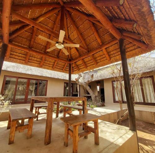 a wooden pavilion with a picnic table and a ceiling fan at 13 Raptors Lodge in Hoedspruit