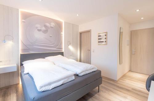 Schlafzimmer mit einem Bett mit weißer Bettwäsche in der Unterkunft Messe-Hotelzimmer-Einzimmerappartement in Leverkusen