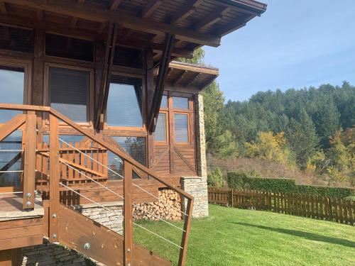 a house with a wooden staircase in a yard at Katarino Mountain House in Razlog
