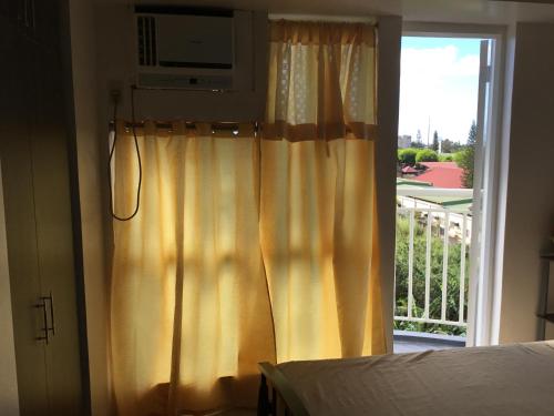 a bedroom with a window with a view of a balcony at Condominium with Swimming Pool and Viewing Deck in Tagaytay