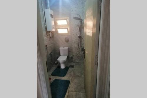 a small bathroom with a toilet and a window at Full Flat cozy place terrific view in Cairo