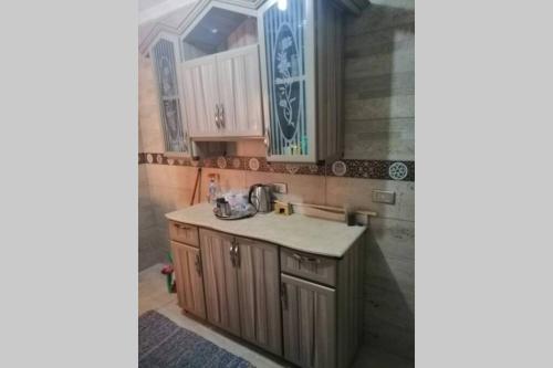 a kitchen with wooden cabinets and a sink at Full Flat cozy place terrific view in Cairo